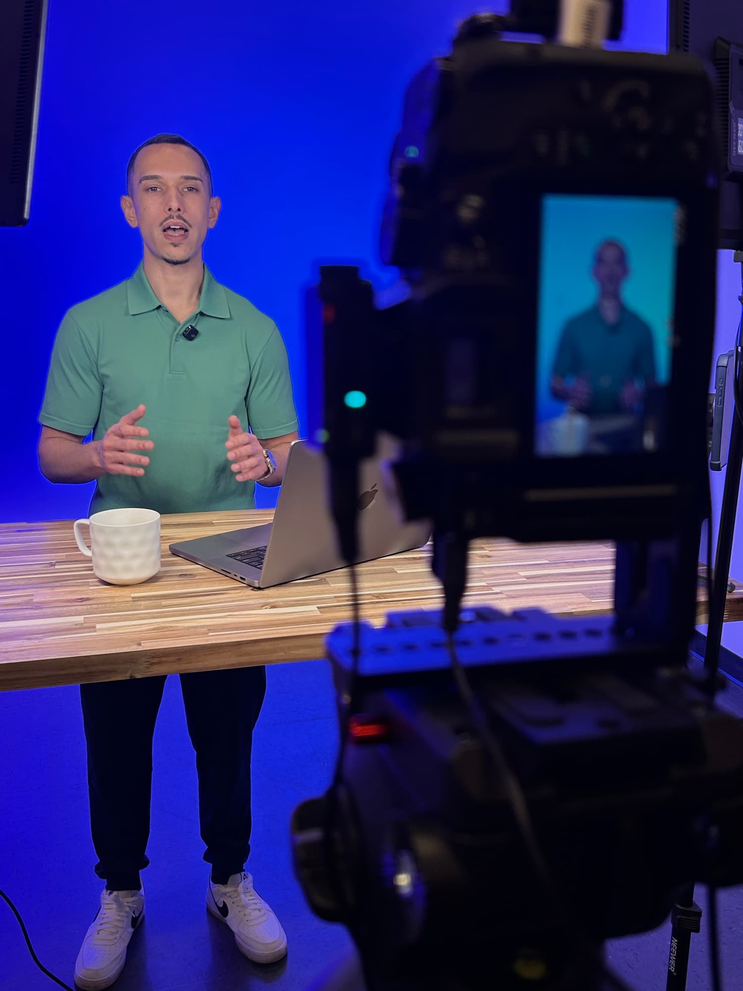 Tournage en studio avec caméra sur pied face à un intervenant sous éclairage bleu