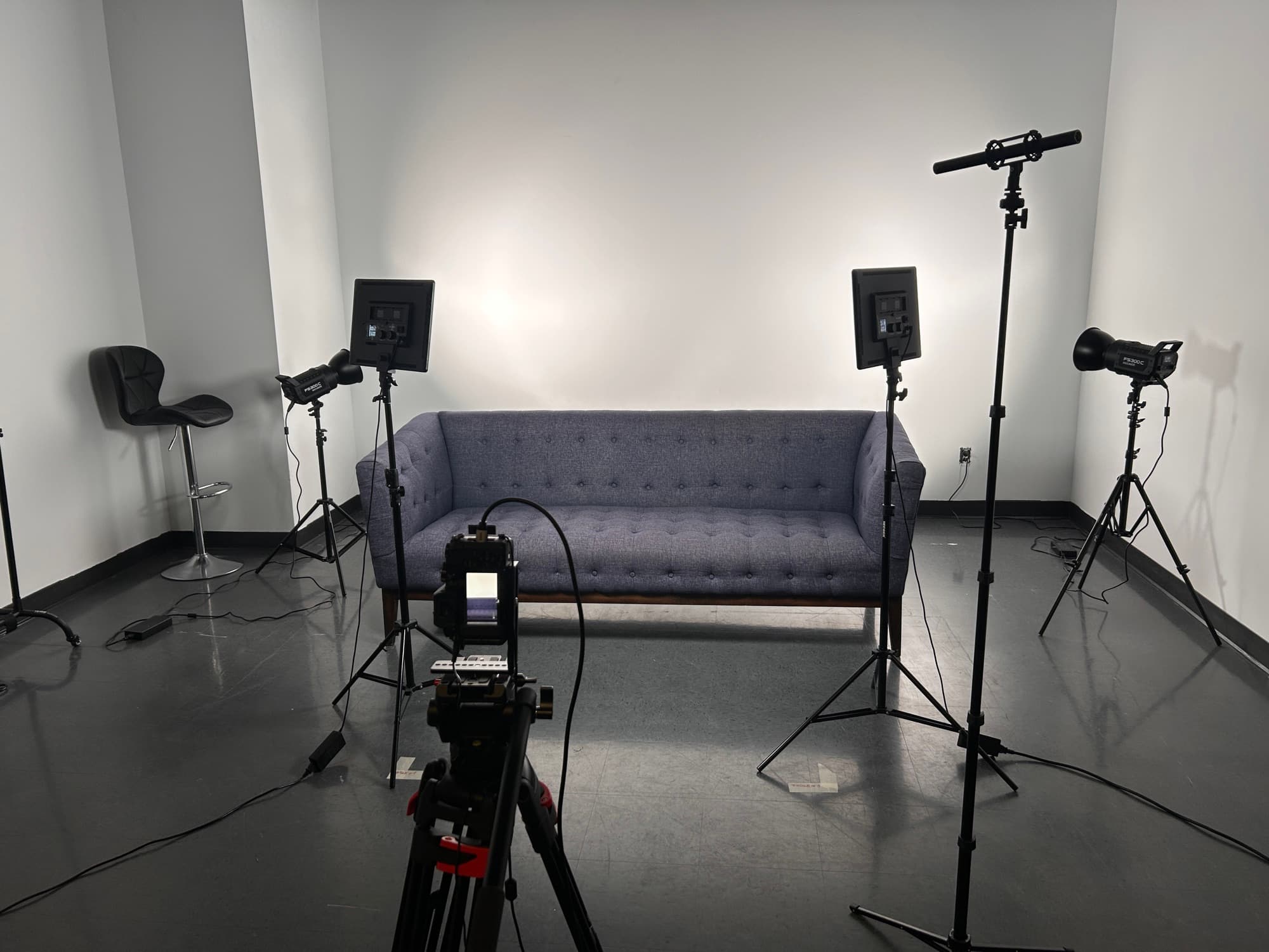 Décor divan et éclairage professionnel prêts pour un tournage au Studio de l'île