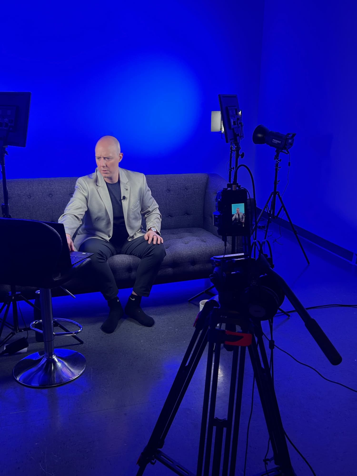 Tournage en cours au Studio de l'île, intervenant filmé sur le décor divan sous éclairage bleu